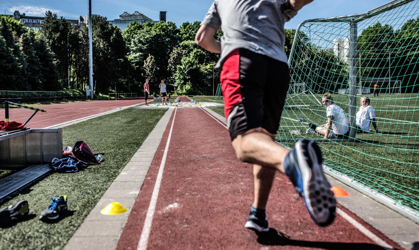 Student aan het lopen in de atletiekpiste van Campus Etterbeek