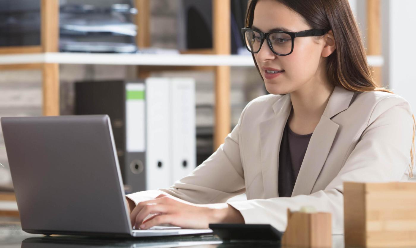 Vrouw werkend op haar laptop aan haar bureau